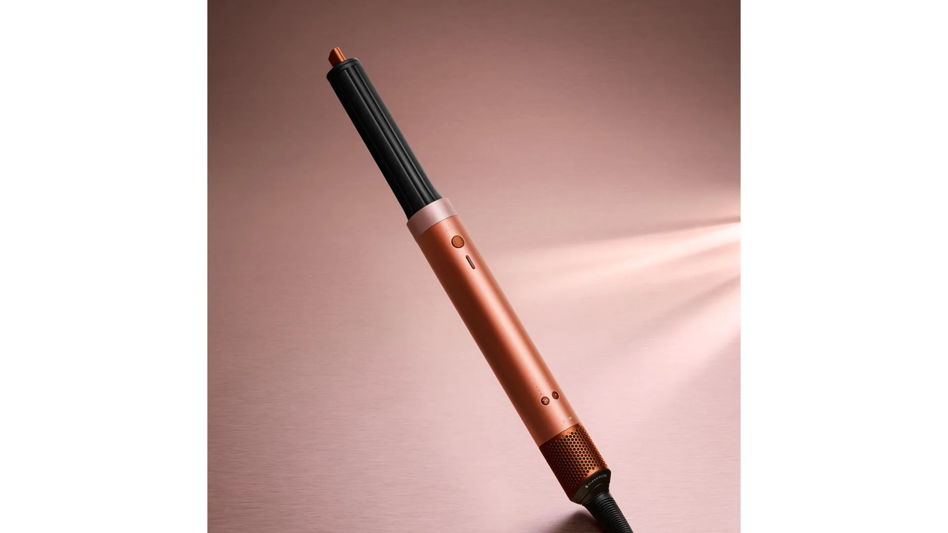 Koperkleurige en zwarte krultang schuin geplaatst op een roze achtergrond.