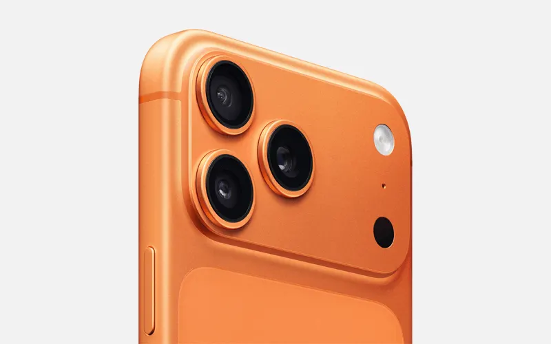Close-up van oranje smartphonehoek met drie cameralenzen en flitser.