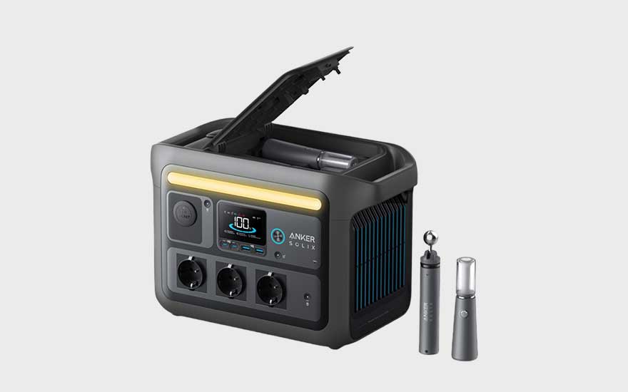 Een compacte, zwarte draagbare stroomgenerator van Anker wordt getoond met open klep en accessoires, klaar voor gebruik binnenshuis of buiten.