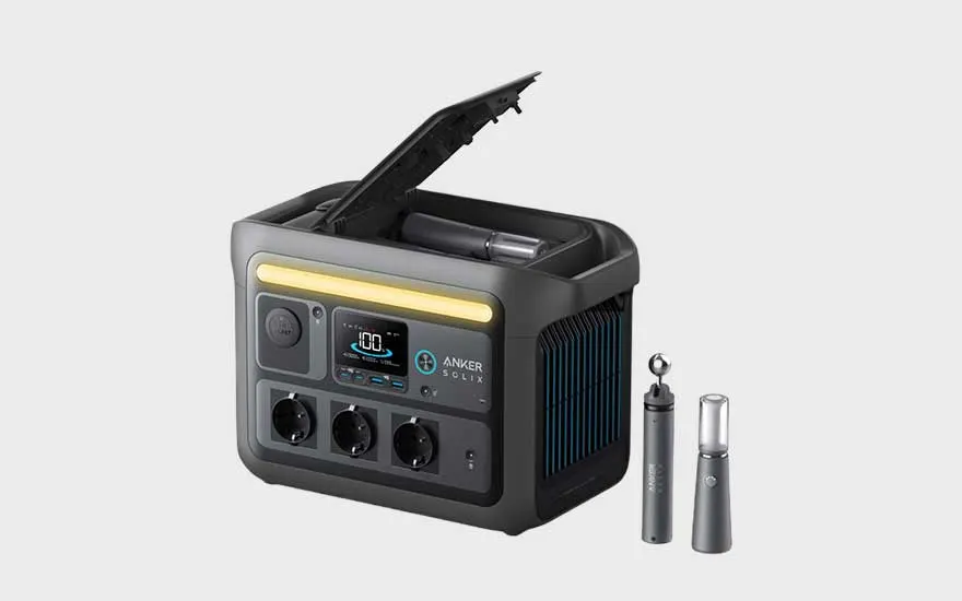 Een compacte, zwarte draagbare stroomgenerator van Anker wordt getoond met open klep en accessoires, klaar voor gebruik binnenshuis of buiten.