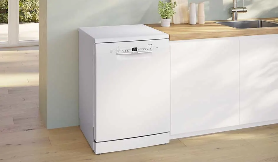 Witte vaatwasser van ok. met digitaal display, geplaatst in een moderne keuken met houten werkblad en minimalistisch design.