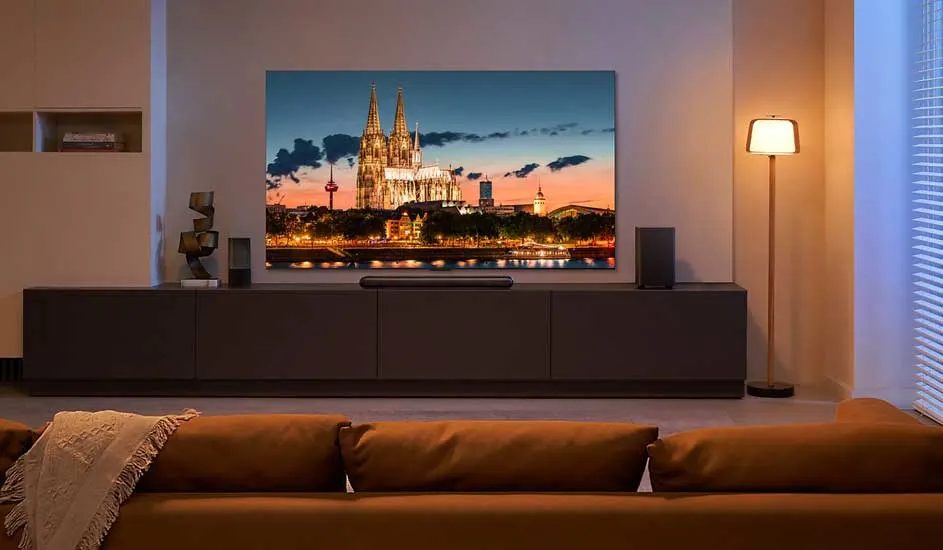 Een Samsung OLED 4K tv met paarse en witte achtergrond staat op een zwarte voet tegen een witte achtergrond.