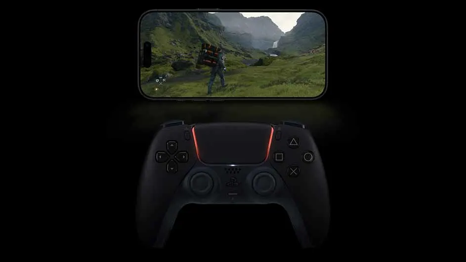Een telefoon toont een spel met bergen en groen gras, boven een zwarte Playstation-controller met oranje accenten, op een zwarte achtergrond.