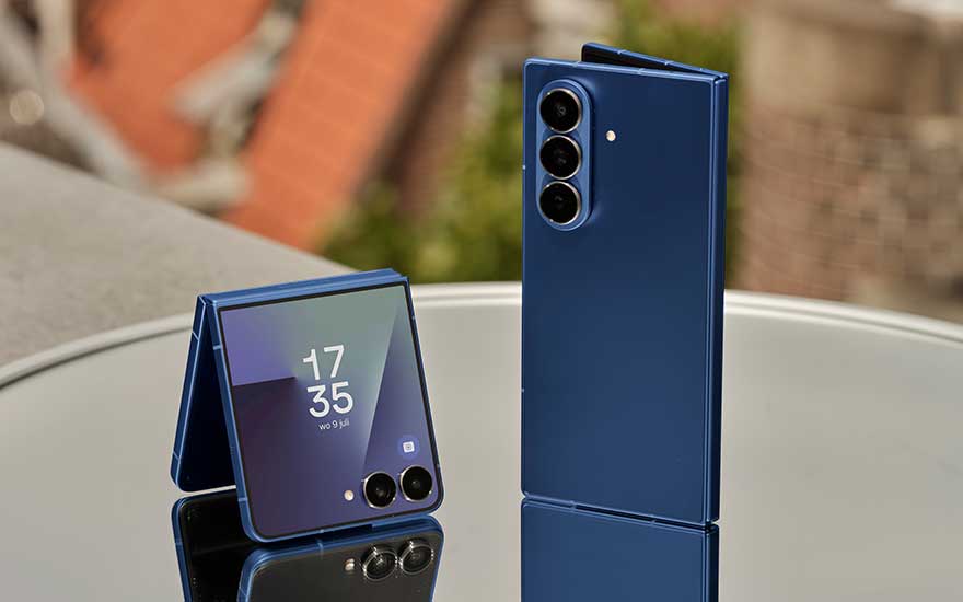 Iemand houdt een smartphone vast met een witte gamecontrollerbevestiging, zittend op een leren bank in een ontspannen setting.