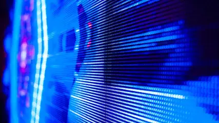 Een blauw verlicht LED-scherm toont horizontale lijnen en rijen met felle lichtpunten. Links zijn vage verticale lijnen.