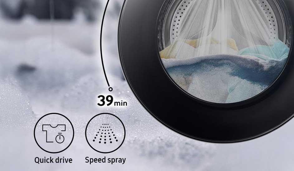 Close‑up van wasmachine met nat wasgoed achter rond raam, timer toont 39 min en icoontjes benadrukken Quick Drive en Speed Spray functies.