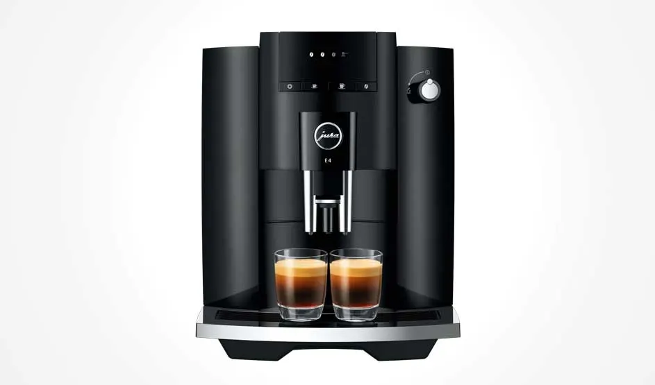 Een zwarte Jura koffiemachine zet twee glazen koffie tegelijk, met schuimlaag bovenop en een draaiknop aan de rechterkant.