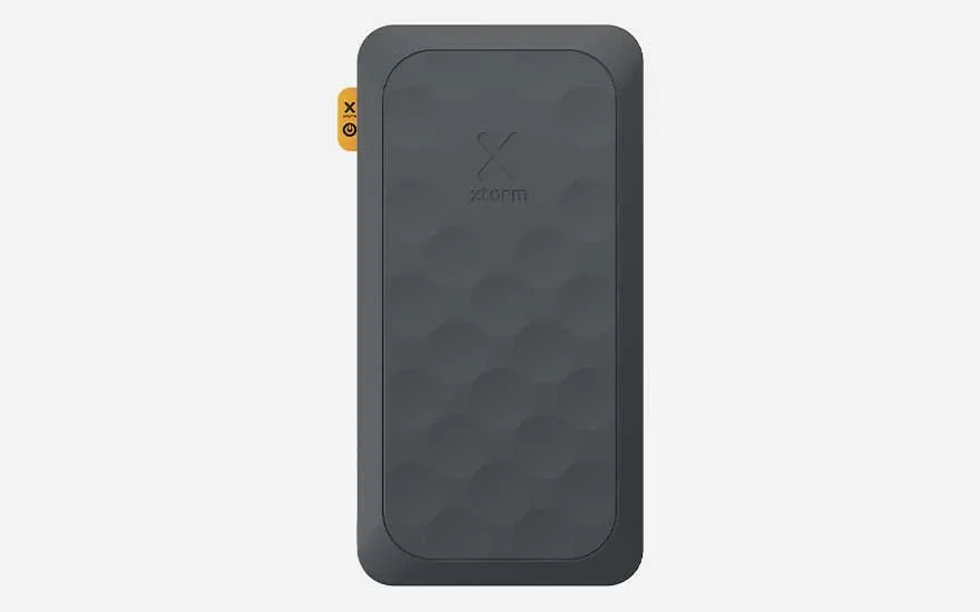 Donkere, robuuste powerbank met subtiel reliëfpatroon en afgeronde hoeken, afgewerkt met klein oranje label langs de zijkant.