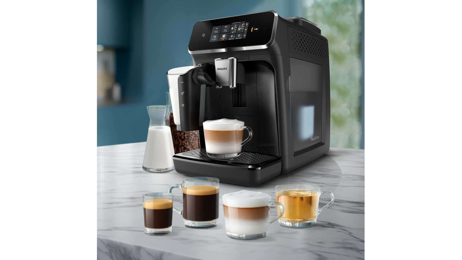 Een zwarte Philips koffiemachine met glazen melkkan en koffiebonen, plus vier glazen met espresso, koffie, latte en thee.