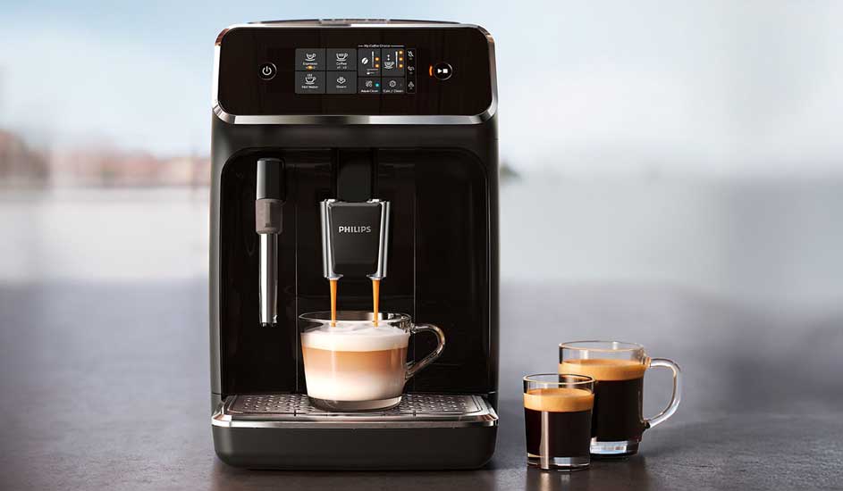 Een zwarte Philips koffiemachine met touchscreen maakt een cappuccino, met daarnaast twee glazen koffie op een grijs aanrecht.