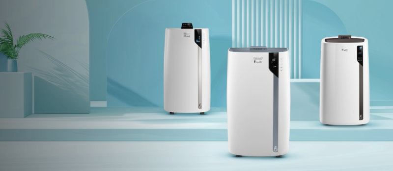 Drie witte luchtreinigers staan in een blauwe kamer met een plant op een kubus.