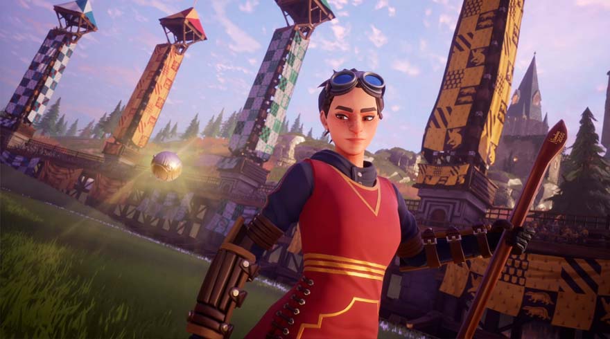 Een persoon met een bril draagt een rood vest met goudkleurige accenten. Op de achtergrond staan torens en een gouden bal.