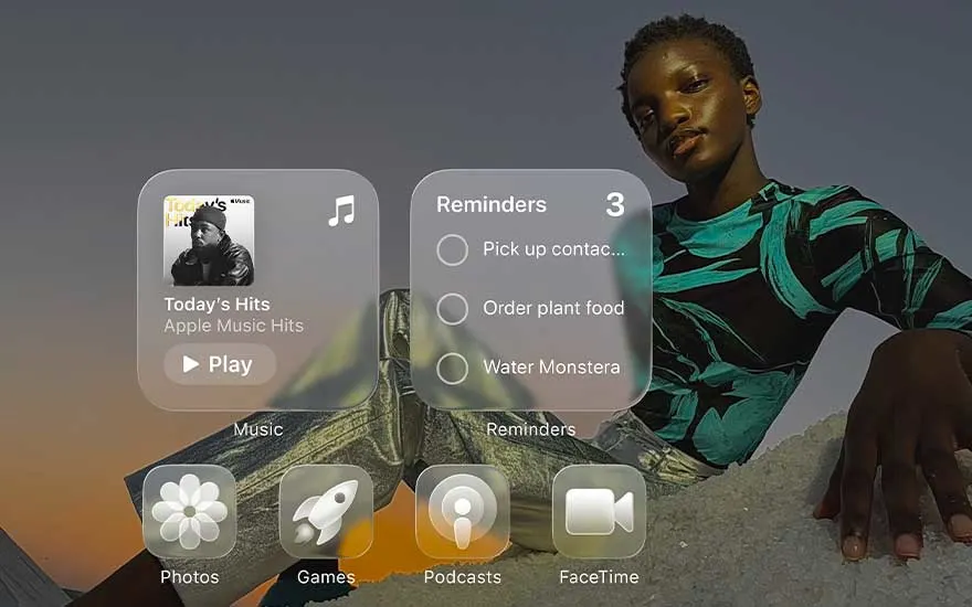 A person poses at sunset behind large floating iPhone widgets for music, reminders, photos, games, podcasts and FaceTime.