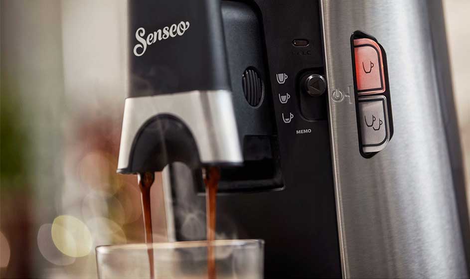 Een open Nespresso-doos toont kleurrijke koffiecapsules in vakjes, met een overzichtskaart van smaken aan de binnenzijde van het deksel.