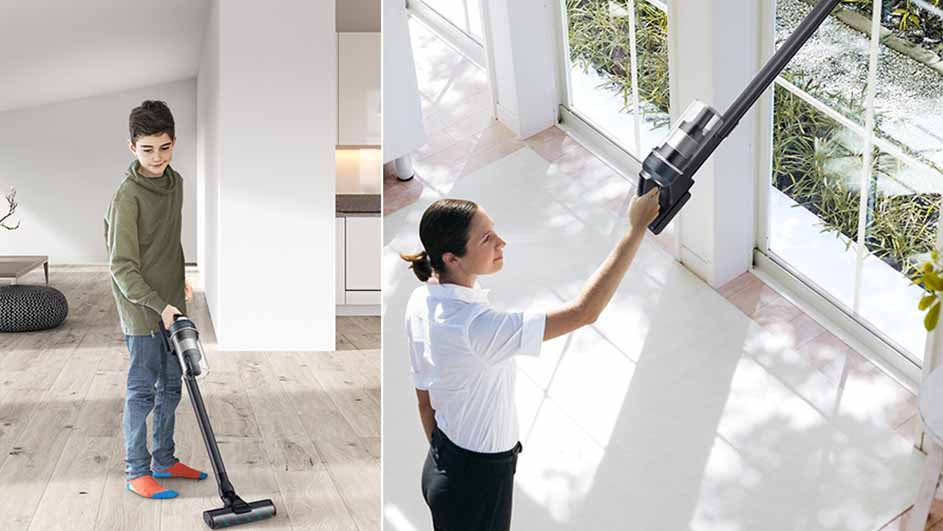 Een jongen stofzuigt een houten vloer, terwijl een vrouw een stofzuiger tegen een raam gebruikt.
