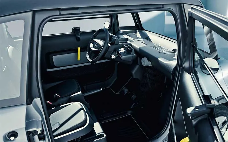 Interieur van de Opel Rocks met open deur, minimalistisch dashboard, compact stuur en twee zitplaatsen.