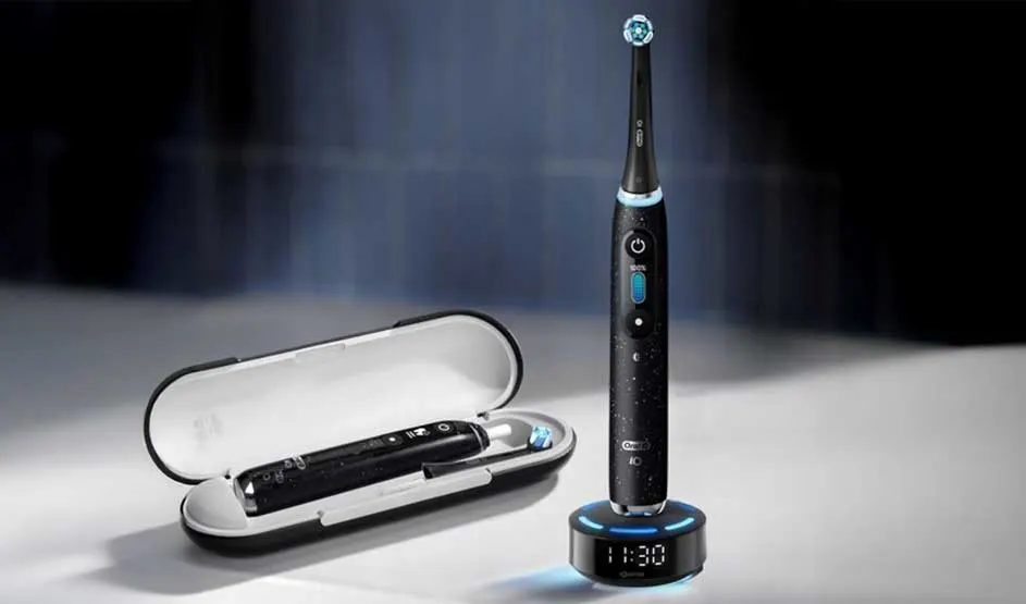 Moderne elektrische tandenborstels met verlichte ringen en standen, gekoppeld aan een smartphone-app die zes poetszones toont.