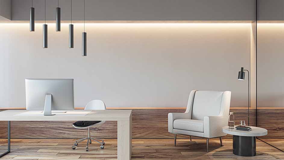 Kantoor met bureau, stoel, computer en lampen. Een witte fauteuil en bijzettafel staan ​​aan de rechterkant. Houten vloer.