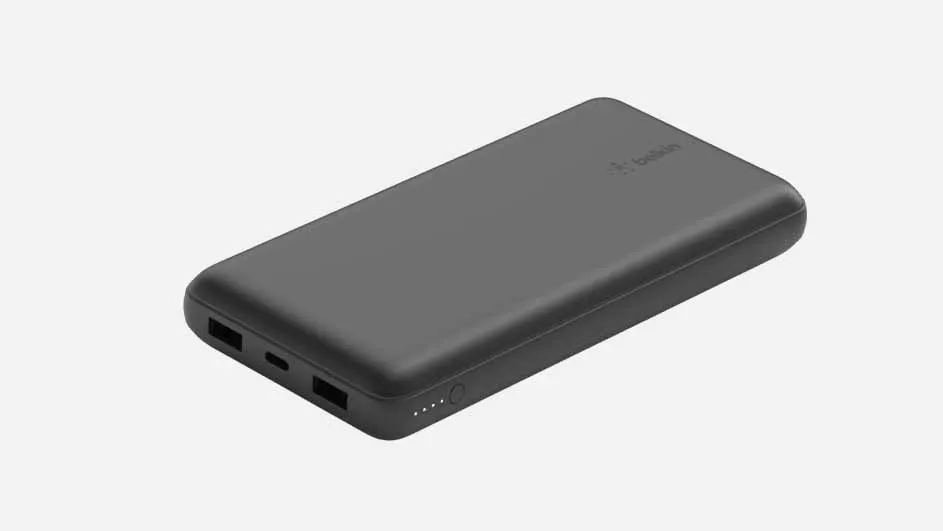 Een grijze, rechthoekige powerbank met afgeronde hoeken ligt op een witte achtergrond, met poorten en indicatielampjes zichtbaar.