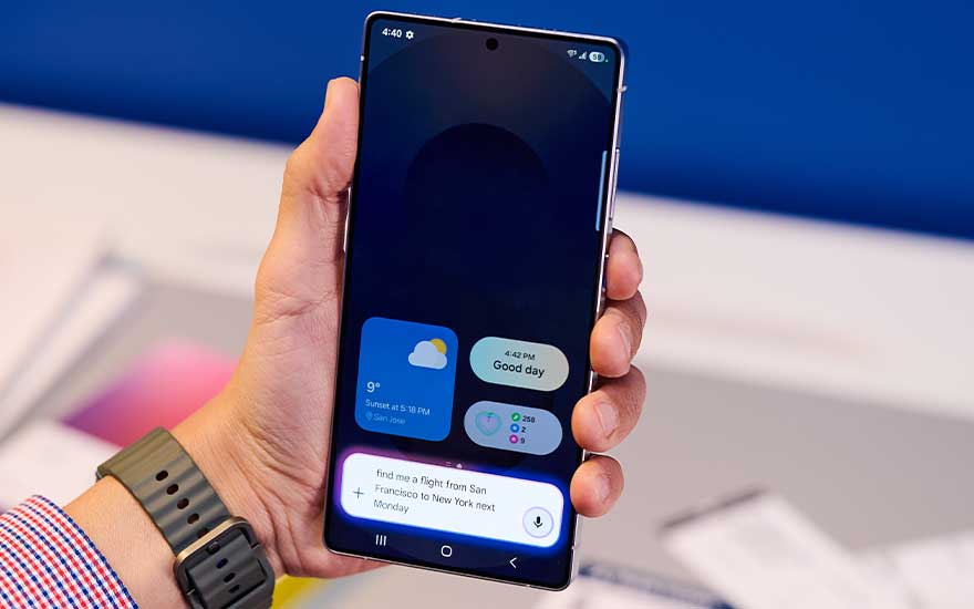 Close-up van de zilverkleurige achterkant van een Samsung-smartphone, met drie verticale cameralenzen en een kleine flitser erboven.