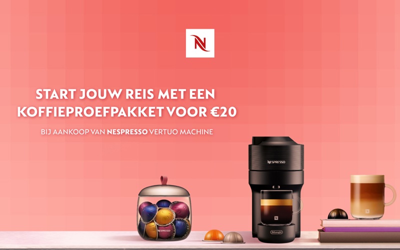Nespresso-promobanner met de tekst “Start jouw reis met een koffieproefpakket voor €20 bij aankoop van Nespresso Vertuo machine”, met een Vertuo-koffiemachine, een pot met capsules, losse capsules en een glas koffie op een roze achtergrond.