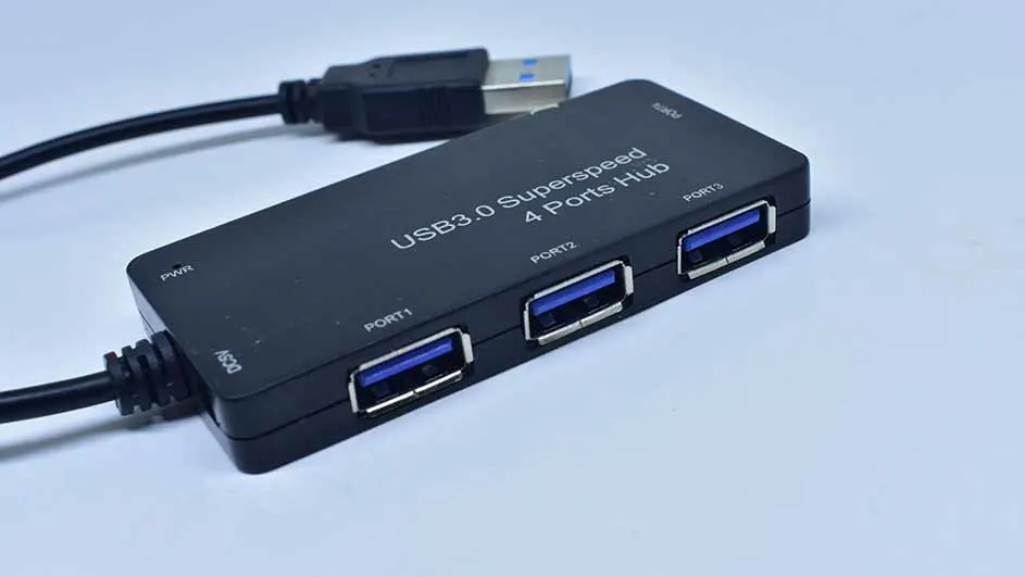 Een zwarte USB 3.0 hub met vier poorten en een USB-kabel op een witte achtergrond.
