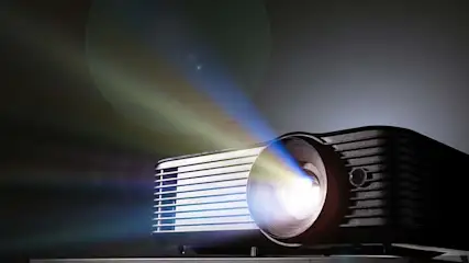 Een projector straalt licht uit in een donkere omgeving. De projector is zwart met witte details.