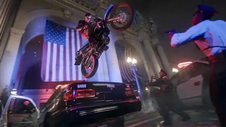 Een man op een motor springt over een zwarte politieauto. Op de achtergrond een Amerikaanse vlag en agenten.