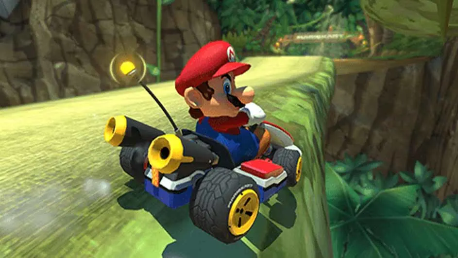 Mario rijdt in een zwarte kart met gele accenten op een groen circuit in een jungle-achtige omgeving.