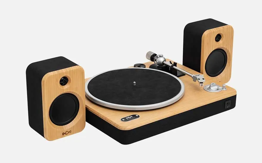 Wooden turntable paired with two matching speakers, a compact hi fi set with black fronts and rounded edges on a white backdrop.