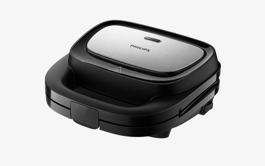 Compact Philips tosti-ijzer in zwart en zilver, met afgeronde hoeken en groot handvat, ontworpen om veilig en ruimtebesparend te grillen.
