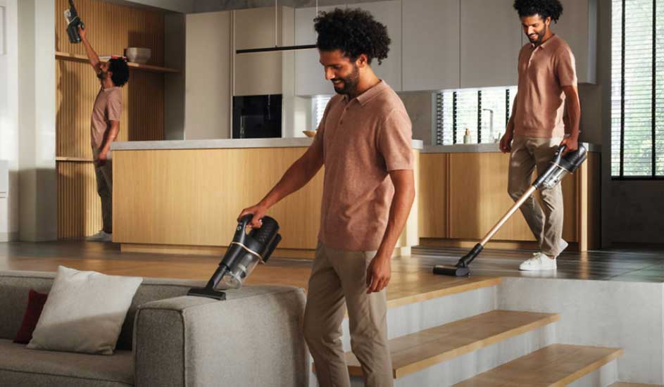 Three people use a Philips cordless vacuum cleaner to clean various areas in a modern living room.