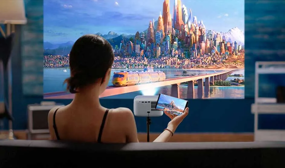 A woman watches a large screen showing a futuristic city; the same scene appears on a smartphone in her hand.