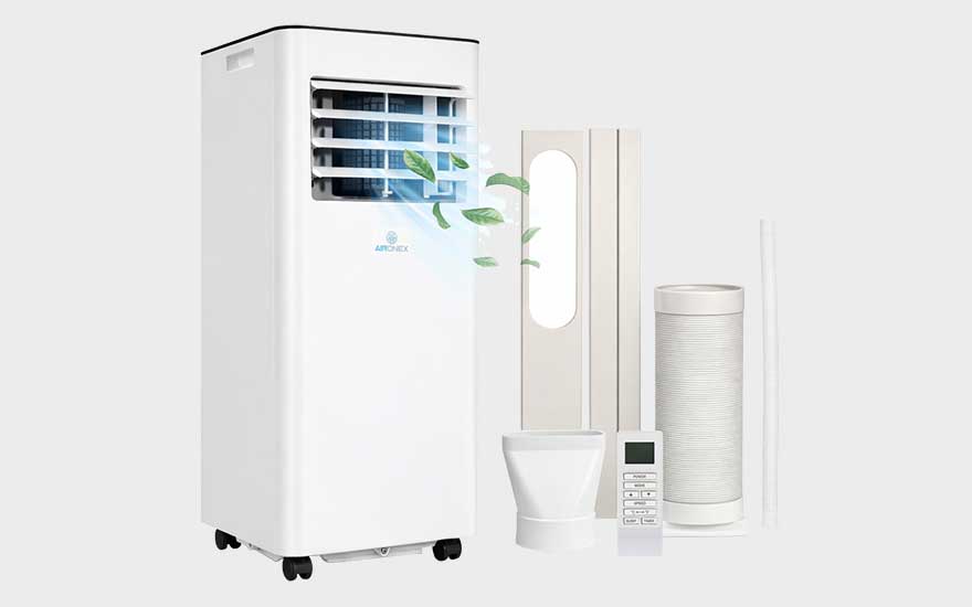 Witte mobiele airco met open luchtrooster, afvoerslang en afstandsbediening, fris afgebeeld met bladeren op lichte achtergrond.