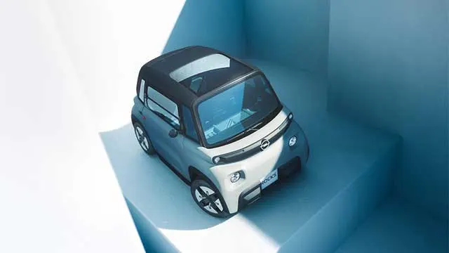 Compacte elektrische Opel Rocks van bovenaf gezien, geparkeerd op lichtblauwe trappen met zonlicht en schaduwen.