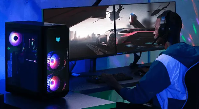 Een persoon met een headset speelt een racegame op een dubbel scherm, met een pc-toren aan de zijkant.