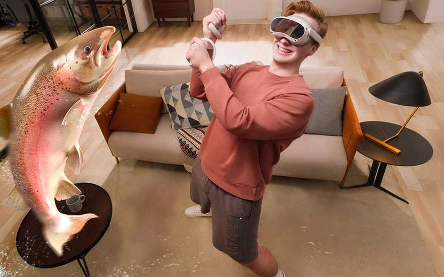 Lachende jongen met VR-bril doet alsof hij een enorme vis vangt in de woonkamer, vis lijkt levensecht en uitvergroot.