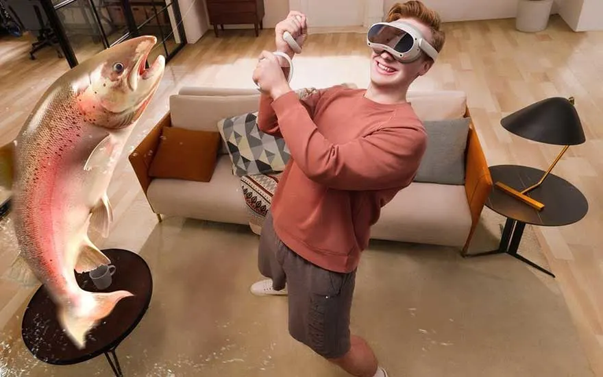 Lachende jongen met VR-bril doet alsof hij een enorme vis vangt in de woonkamer, vis lijkt levensecht en uitvergroot.
