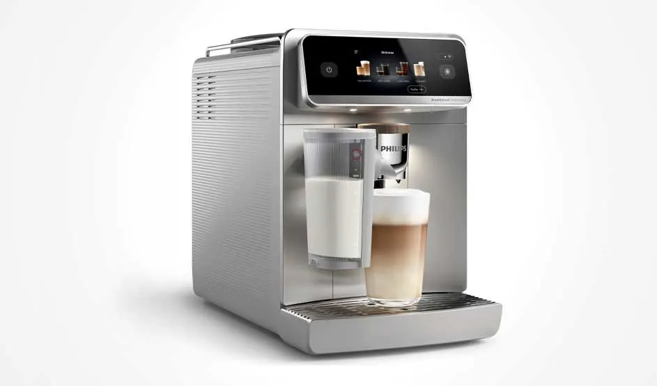 Een zilveren volautomatische koffiemachine maakt een latte in een glas, met een melkreservoir en digitaal display bovenaan.