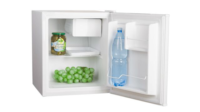 Een open, witte koelkast bevat groene druiven, een pot augurken en een fles water.