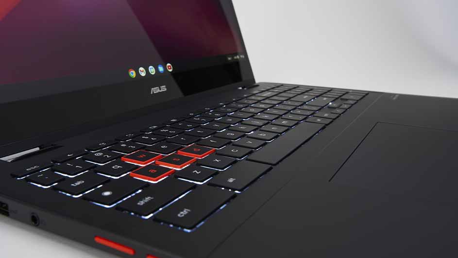 Een zwarte ASUS laptop met rode accenten op sommige toetsen en een touchpad, tegen een witte achtergrond.