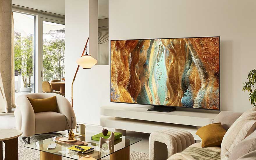 Stylish living room with white furniture and a TV on a low stand, displaying colourful, organic-looking digital artwork.