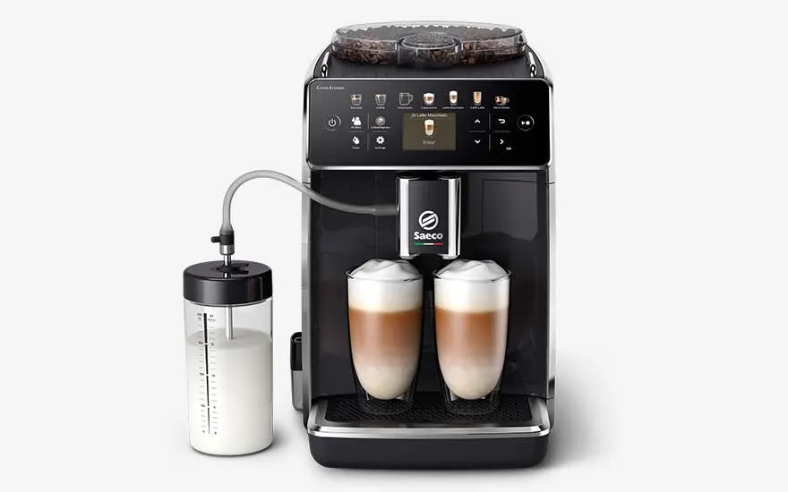 Black Saeco coffee machine with a touchscreen, two glasses of latte macchiato and a milk container on the side.