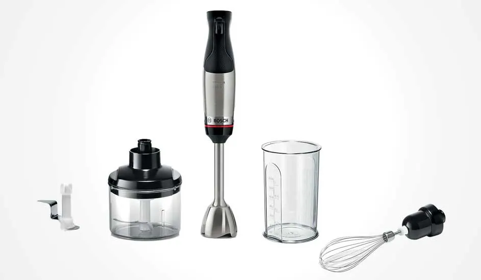 Bosch staafmixer in zwart en zilver met hakmolen, maatbeker, garde en extra mes, alle onderdelen netjes uitgelijnd op witte achtergrond.