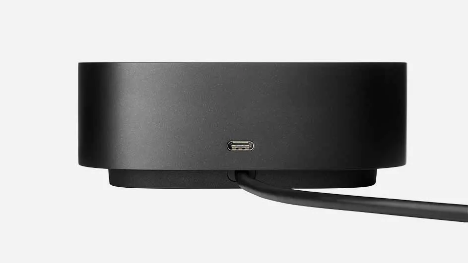 Een zwarte, cilindervormige oplader met een USB-C-poort en een zwarte kabel op een witte achtergrond.