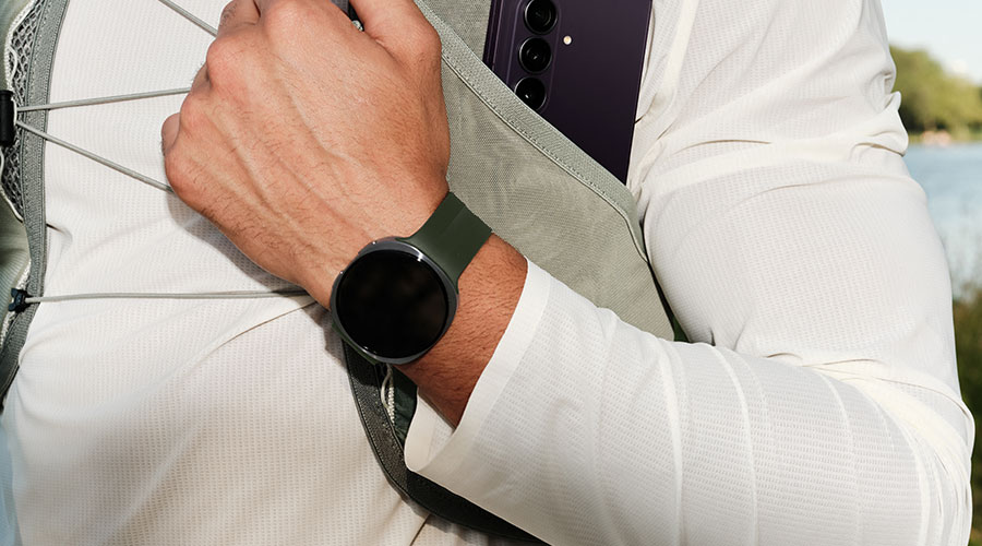 Persoon draagt een Galaxy Watch en heeft een opvouwbare Samsung-smartphone in een borsttas.