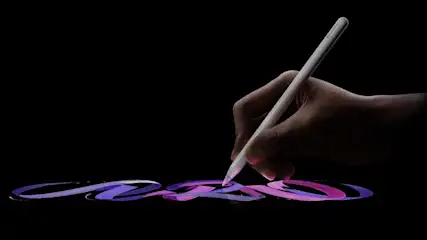 Een hand houdt een witte stylus boven paarse en blauwe lijnen op een zwarte achtergrond.