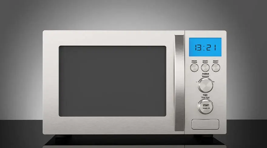 Een witte magnetron met knoppen en een blauw digitaal display staat op een zwarte ondergrond tegen een grijze achtergrond.