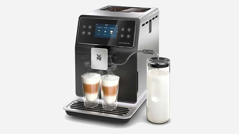 Een koffiemachine met melkkan en twee glazen latte macchiato op een wit oppervlak.