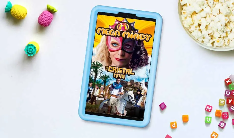 Een tablet met een blauwe hoes toont een kleurrijke kinderserie. Er liggen popcorn, letterblokjes en gekleurde ananasjes omheen. Merk is niet zichtbaar.